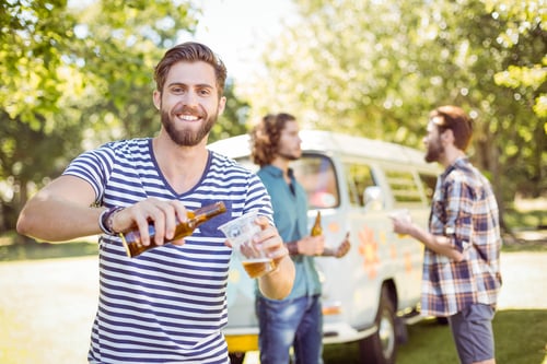 Hipster friends having a beer together on a summers day